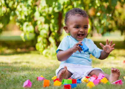 african american baby boy playing in the grass